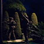 Militares equipados con cascos durante un operativo nocturno en una zona con vegetación.