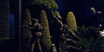 Militares equipados con cascos durante un operativo nocturno en una zona con vegetación.