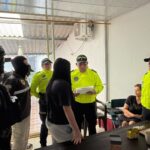 Agentes uniformados junto a dos mujeres en una habitación.