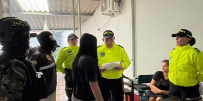 Agentes uniformados junto a dos mujeres en una habitación.