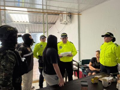 Agentes uniformados junto a dos mujeres en una habitación.