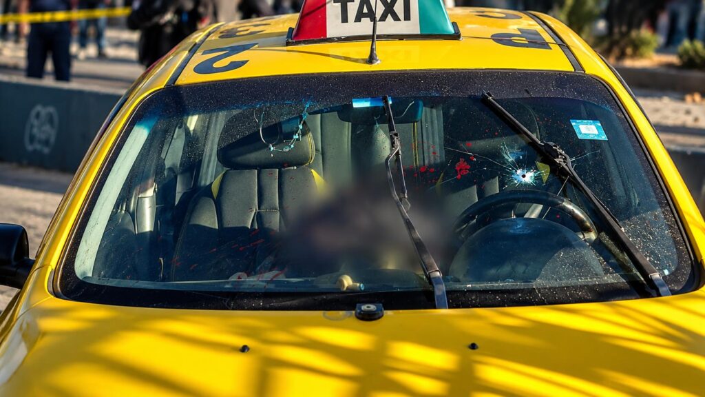 Taxi amarillo visto de frente, con parte de su interior difuminada.