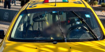 Taxi amarillo visto de frente, con parte de su interior difuminada.