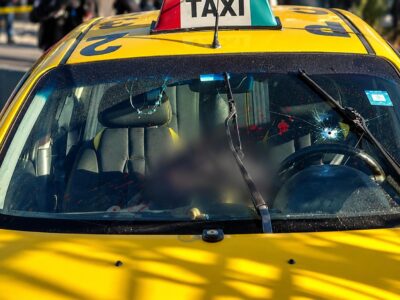 Taxi amarillo visto de frente, con parte de su interior difuminada.