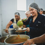 Personal de un Comedor Guayaco sirve comida desde ollas grandes durante la apertura del programa municipal en Guayaquil, el 12 de octubre de 2026.