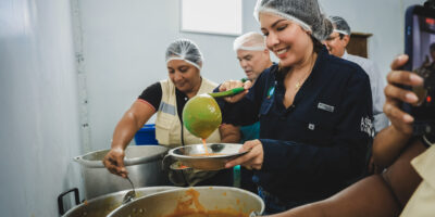 Personal de un Comedor Guayaco sirve comida desde ollas grandes durante la apertura del programa municipal en Guayaquil, el 12 de octubre de 2026.