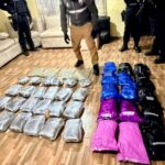 Paquetes envueltos en plástico alineados en el piso de una vivienda, con agentes de pie alrededor, durante uno de los allanamientos del 7 de octubre de 2026.