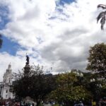 Cielo con sol y nubes sobre una plaza del centro histórico de Quito.