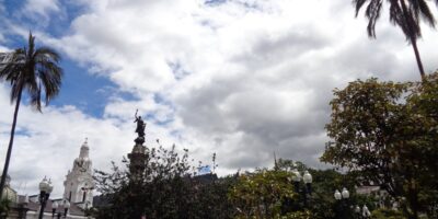 Cielo con sol y nubes sobre una plaza del centro histórico de Quito.