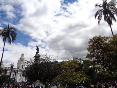 Cielo con sol y nubes sobre una plaza del centro histórico de Quito.