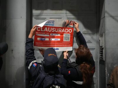 Personal de la Agencia Metropolitana de Control coloca un sello de clausura en la puerta de un establecimiento de Quito.