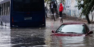 Un autobús y un automóvil en una calle cubierta por agua.