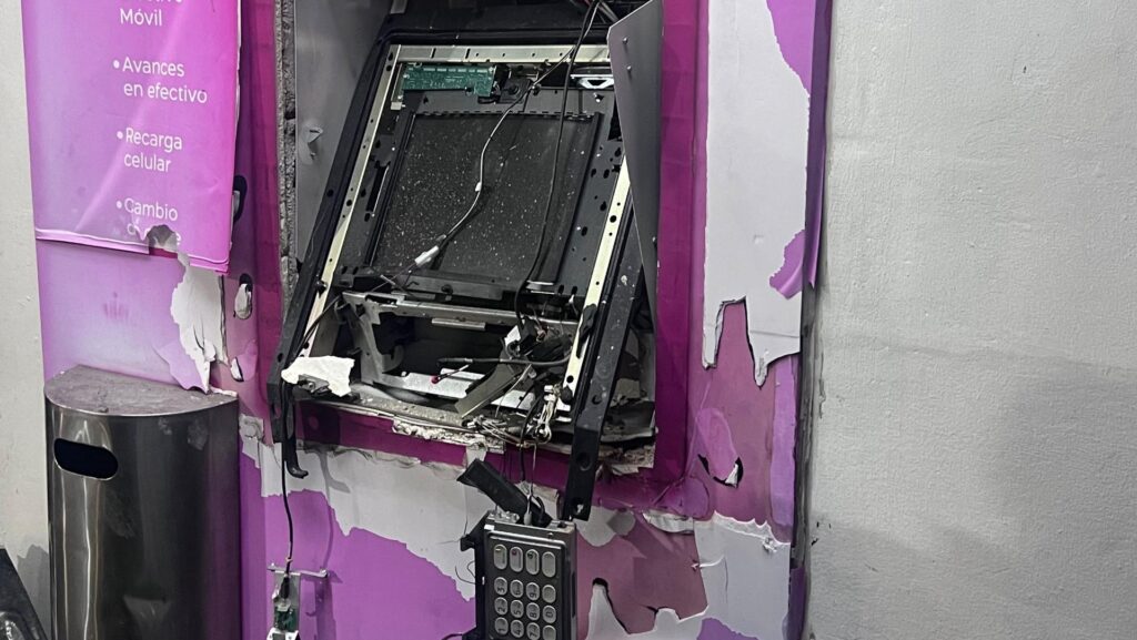 Cajero automático con su estructura exterior dañada y componentes internos expuestos.