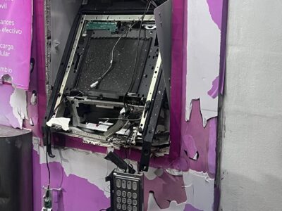 Cajero automático con su estructura exterior dañada y componentes internos expuestos.