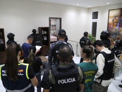 Agentes de Policía y otras personas en el interior de una vivienda durante un operativo.