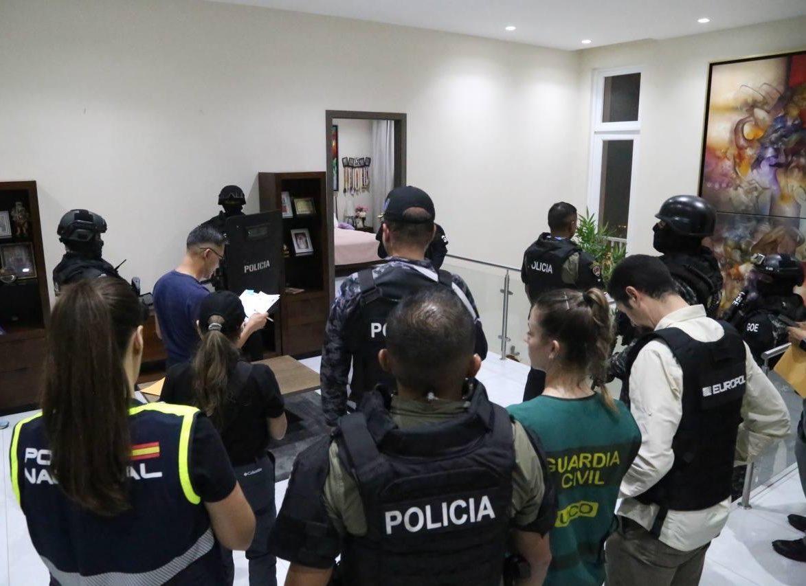 Agentes de Policía y otras personas en el interior de una vivienda durante un operativo.